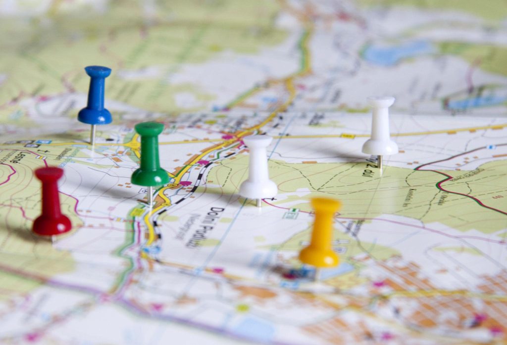 paper map with colored pins stuck in it